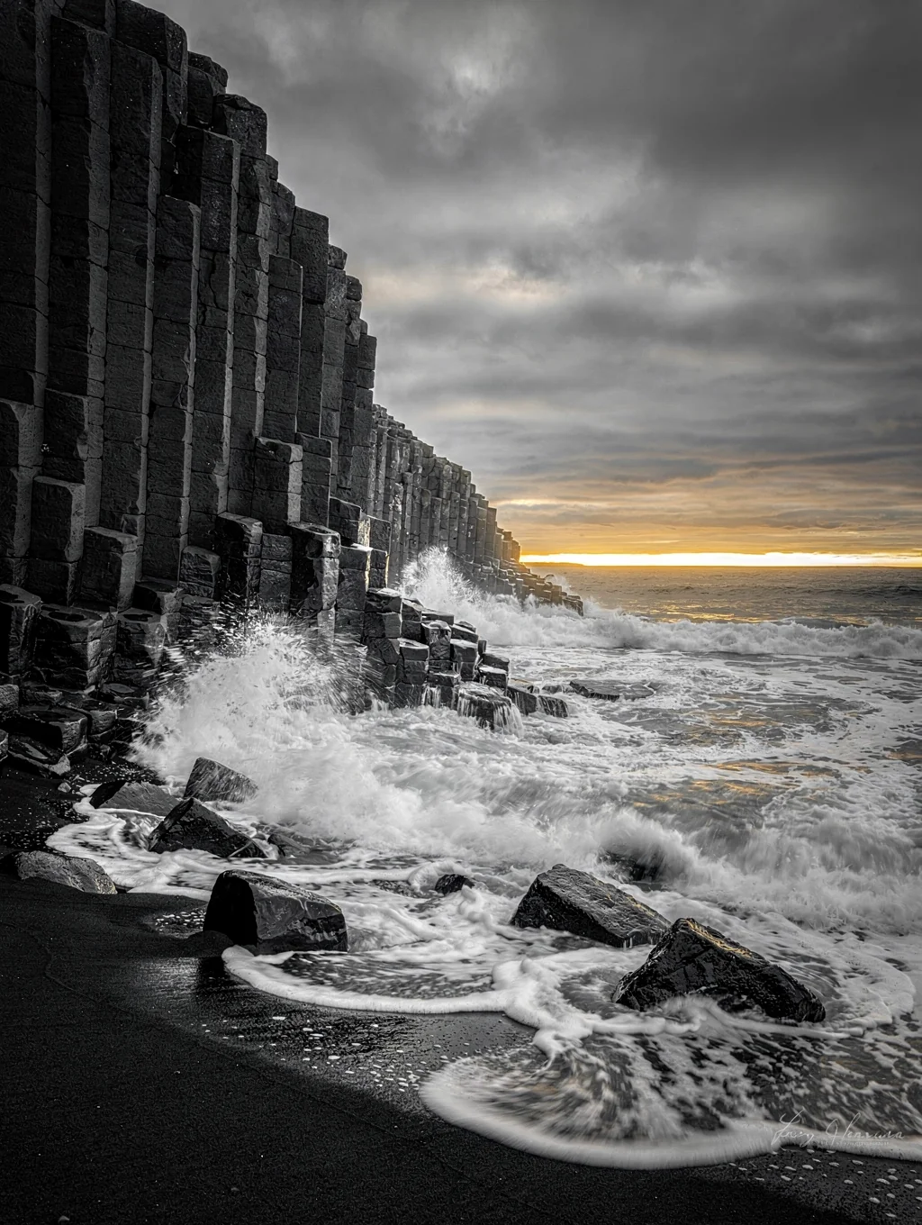 Hexagonal volcanic basalt columns along the black sand beach